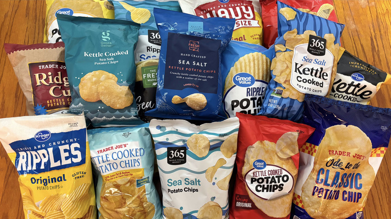 Various store-brand plain potato chips on wooden table