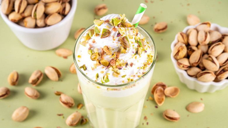 pistachio milkshake with bowls of nuts and shells