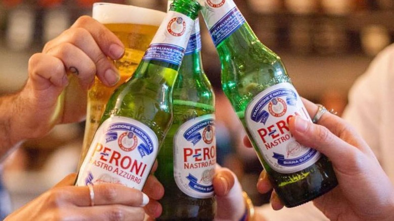 Bottles of Peroni being clinked together