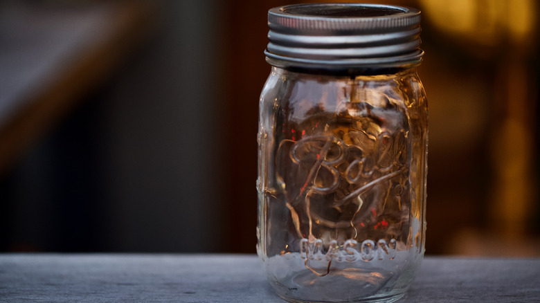 A Ball Mason jar sitting on a stoop