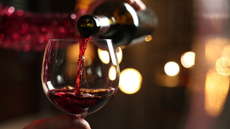 Pouring red wine from a bottle into a glass