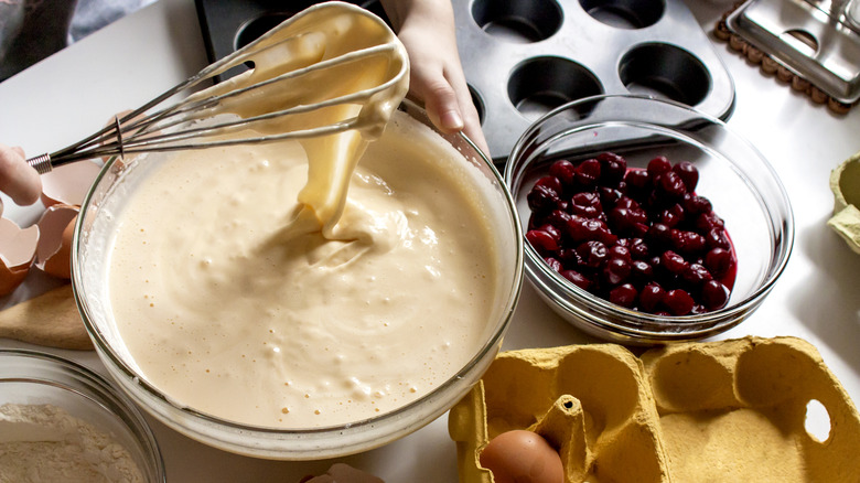mixing cake batter dripping from whisk